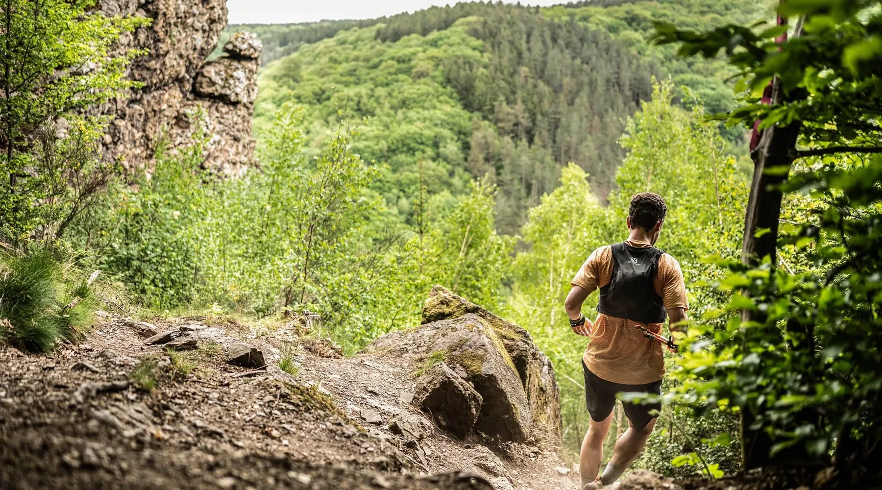Coureur sur une crête rocheuse au-dessus de la vallée du Ninglinspo