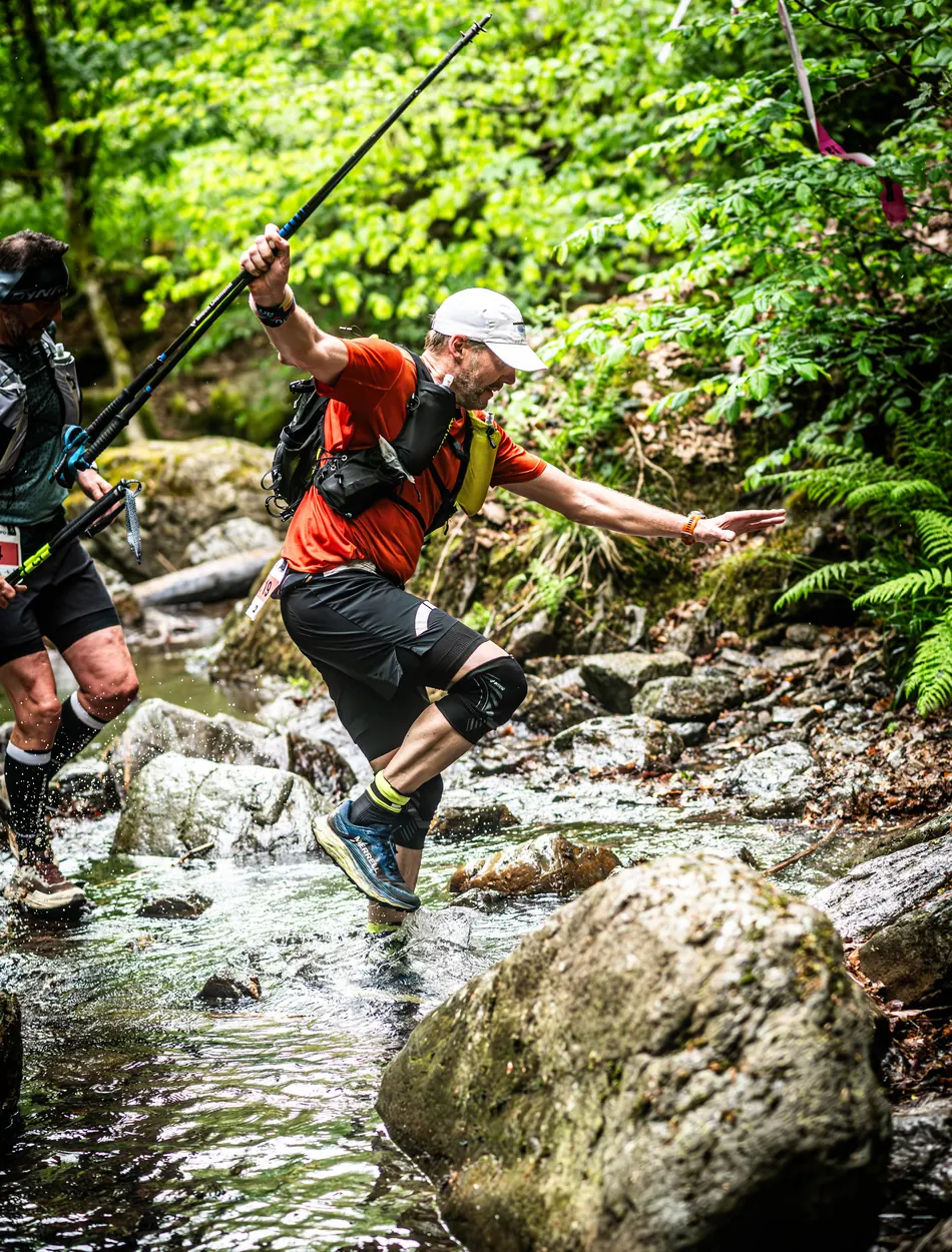 Coureur franchissant une dalle rocheuse moussue